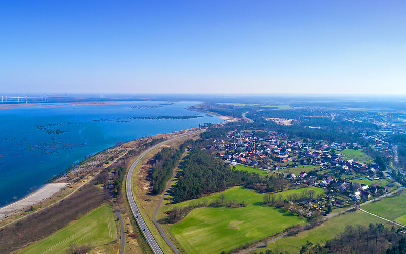 Auf dem Foto ist der Cottbuser Ostsee am Rand der Stadt zu sehen. Seine riesige Fläche erstreckt sich beeindruckend im Bild.